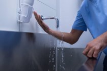 Sezione media di chirurgo maschio che si lava le mani con sapone in lavandino in ospedale — Foto stock