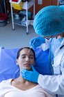 Hochwinkelaufnahme eines kaukasischen Chirurgen, der einer kaukasischen Patientin im Krankenhaus eine Injektion ins Gesicht verabreicht — Stockfoto