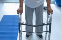 Низька частина пацієнта чоловічої статі, що ходить з ходунками в палаті в лікарні — стокове фото