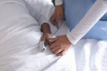Seção intermediária de médico feminino consolando paciente feminina na enfermaria do hospital — Fotografia de Stock