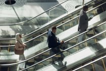 Luftaufnahme diverser Geschäftsleute, die Rolltreppen in modernen Büros nutzen — Stockfoto
