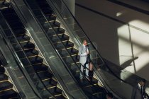 Aerial view of mature African-american executive using escalators in modern office — Stock Photo