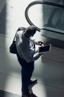 High-Winkelansicht eines afrikanisch-amerikanischen Geschäftsmannes, der im modernen Büro auf ein digitales Tablet blickt — Stockfoto