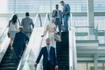 Frontansicht diverser Geschäftsleute, die Rolltreppen in modernen Büros nutzen — Stockfoto