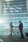 Low angle view of business people shaking hands in the modern office building — Stock Photo