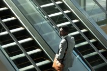 Вид сбоку африканского бизнесмена, стоящего в лифте в современном офисе — стоковое фото