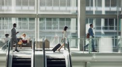 Вид сбоку на разношерстных бизнесменов, гуляющих в современном офисе — стоковое фото