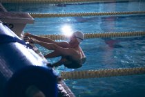 Vista lateral de um nadador caucasiano macho agarrado aos lados da piscina — Fotografia de Stock