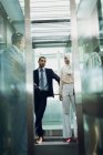 Vue à faible angle de divers hommes d'affaires utilisant l'ascenseur dans le bureau moderne — Photo de stock