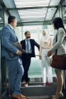 Низький кут зору різних бізнесменів, що використовують ліфт в сучасному офісі — стокове фото