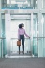Vista frontale dell'esecutivo afroamericano femminile che prende l'ascensore in un ufficio moderno — Foto stock