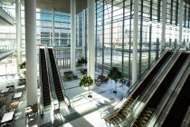 Modern office with windows and escalators in city — Stock Photo