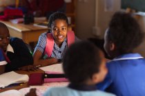 Nahaufnahme einer Gruppe junger afrikanischer Schülerinnen und Schüler, die sich während einer Unterrichtspause in einem Klassenzimmer der Township-Grundschule treffen — Stockfoto