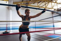 Вид на жіночий боксер гімнастика у боксерський ринг у клубі боксу. Сильні жінки винищувач в бокс тренажерний зал навчання жорсткий. — стокове фото