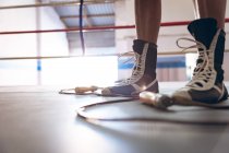 Low section of female boxer standing in boxing ring at fitness center. Strong female fighter in boxing gym training hard. — Stock Photo