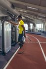 Athlétisme masculin handicapé afro-américain réfléchi debout sur la piste de course dans un centre de fitness — Photo de stock