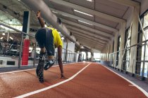 Вид сзади на атлетический бег афроамериканцев на ипподроме в фитнес-центре — стоковое фото