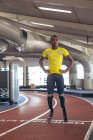 Front view of disabled African American male athletic standing on running track in fitness center — Stock Photo