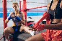 Pugili afro-americani con indosso la fascia a mano al club di boxe. Forte combattente femminile in palestra di pugilato allenamento duro . — Foto stock