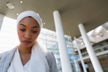 Visão de baixo ângulo de empresária em hijab olhando para baixo em um escritório moderno . — Fotografia de Stock