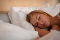 Close up de uma jovem mulher caucasiana dormindo na cama . — Fotografia de Stock