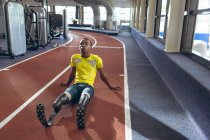 Вид з інвалідів афроамериканець чоловічий Атлетичний відпочиваючи на бігові доріжки в фітнес-центр — стокове фото