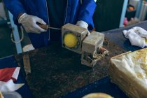 Visão frontal seção média do homem abrindo um molde para produzir o núcleo de uma bola em uma oficina em uma fábrica de bolas de críquete . — Fotografia de Stock