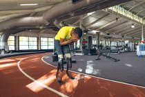 Front view of disabled African American male athletic disappointed after losing race in fitness center — Stock Photo