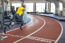 Visão traseira do atlético masculino afro-americano deficiente correndo em pista de corrida no centro de fitness — Fotografia de Stock
