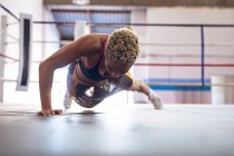 Boxeuse afro-américaine faisant de l'exercice en boxe au centre de remise en forme. Forte combattante dans la boxe gymnase entraînement dur . — Photo de stock