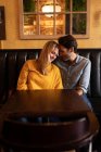 Vista frontale di una giovane coppia caucasica felice che si rilassa insieme in vacanza in un bar, abbracciando — Foto stock
