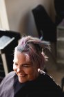 Vista frontale da vicino di una giovane donna caucasica che si fa acconciare i capelli in un parrucchiere — Foto stock