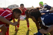 Vista laterale di due squadre avversarie di giovani giocatrici di rugby multietniche in attesa che la palla venga lanciata prima di una mischia durante una partita di rugby — Foto stock