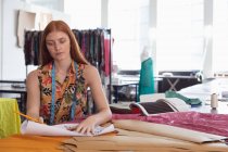 Frontansicht einer jungen kaukasischen Modestudentin, die in einem Atelier der Modehochschule an einem Design arbeitet — Stockfoto