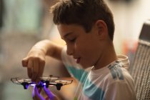 Side view close up of a pre teen Caucasian boy holding a drone at home — Stock Photo