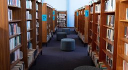Innenraum einer Bibliothek mit Sitzgelegenheiten und Bücherregalreihen — Stockfoto
