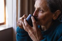 Nahaufnahme einer älteren kaukasischen Frau, die zu Hause Kaffee trinkt — Stockfoto