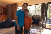 Ritratto di due ragazzi caucasici pre-adolescenti in salotto a casa in cerca di una telecamera — Foto stock