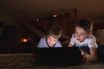 Vista frontale da vicino di due ragazzi caucasici pre-adolescenti che usano un tablet in salotto — Foto stock