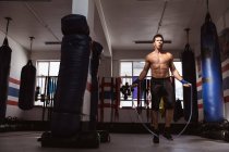 Frontansicht eines jungen kaukasischen Boxers, der in einer Boxhalle hüpft — Stockfoto