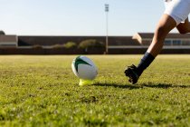 Seitenansicht Unterteil einer Rugby-Spielerin, die zum Ball rennt, um einen Platzkick zu machen — Stockfoto