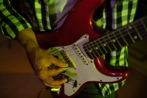 Vista frontal parte do meio do homem tocando uma guitarra elétrica durante uma sessão em um estúdio de gravação — Fotografia de Stock