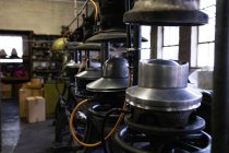 Вид сбоку ряда старых машин, используемых в процессе изготовления люков в мастерской на шляпной фабрике — стоковое фото