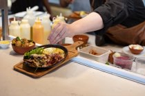 Frontansicht Mittelteil der Köchin garniert ein Gericht, das in einer Restaurantküche serviert werden kann — Stockfoto