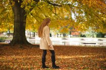 Side-view of woman walking in the park. — Stock Photo