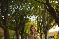 Woman with her hands folded standing in the park. — Stock Photo