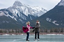 Vista lateral do feliz casal caucasiano dançando em pé na paisagem nevada natural — Fotografia de Stock