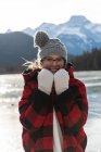 Portrait of happy young Caucasian woman standing in natural snowy landscape with winter outfit. — Stock Photo