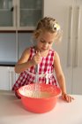 Front view close up of a young Caucasian girl mixing food in a bowl cooking in the kitchen — Stock Photo