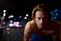 Portrait of a young Caucasian man in the street during his late evening workout — Stock Photo
